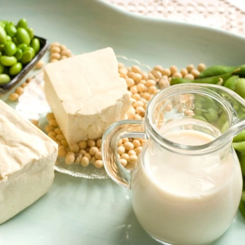 Verschiedene Sojaprodukte auf einem Teller, darunter Edamame, Sojabohnen, Tofu und Sojamilch.