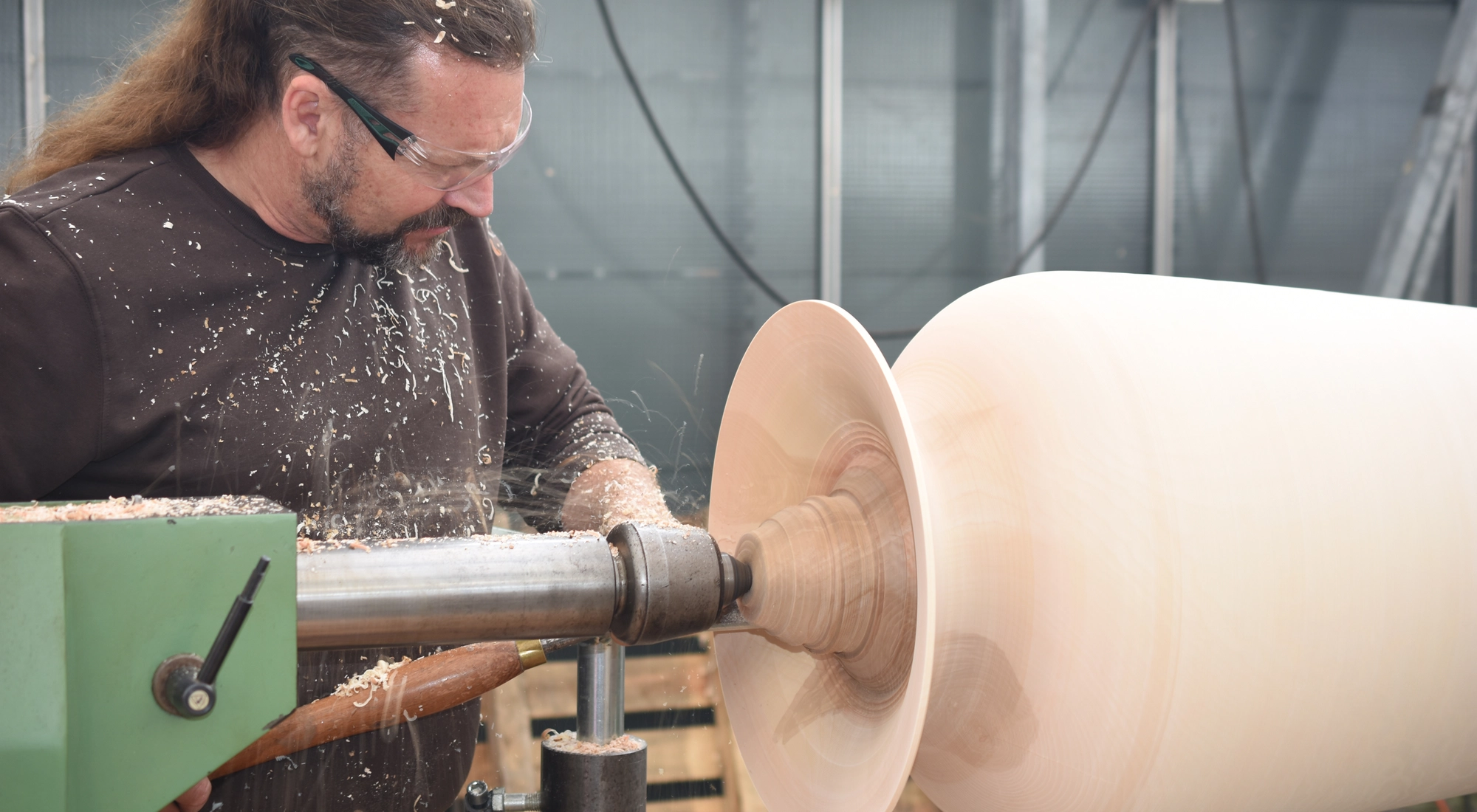 Mann fertigt ein Holzstück an. 