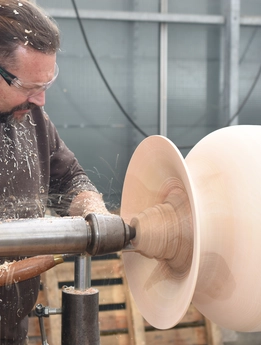Mann fertigt ein Holzstück an. 