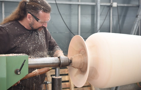 Mann fertigt ein Holzstück an. 