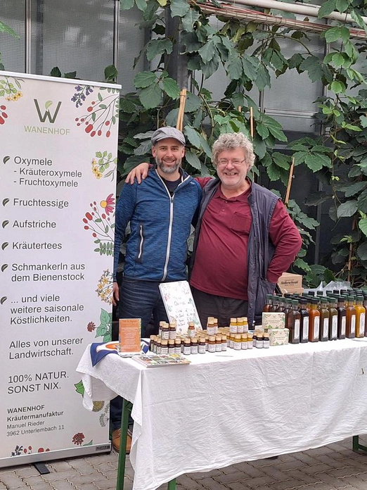 Man kann zwei Männer hinter ihren Marktstand mit ihren selbstgemachten, regionalen Produkten.